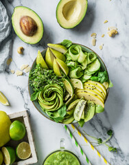 Fresh summer salad with avocado, kiwi, apple, cucumber, pear, micro greens, lime and sesame on light marble background with smoothie. Healthy food, clean eating, Buddha bowl salad, top view