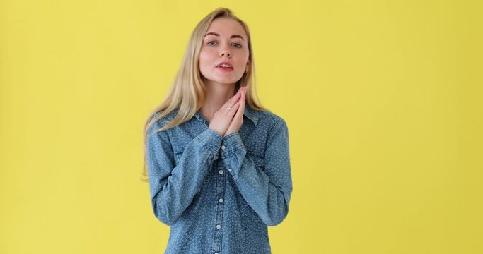 Shocked woman covering her mouth with hand over yellow background