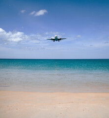 Fototapeta na wymiar a passenger plane lands low over the sea, at an airport near the beach on a Sunny day