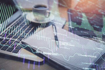 Double exposure of forex chart drawing and desktop with coffee and items on table background. Concept of financial market trading