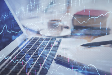 Double exposure of financial chart drawing and desktop with coffee and items on table background....