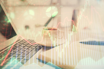 Double exposure of financial chart drawing and desktop with coffee and items on table background. Concept of forex market trading