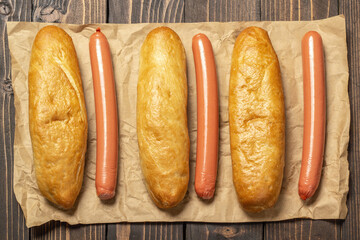 A bunch of sausages wrapped in brown paper on an old wooden table