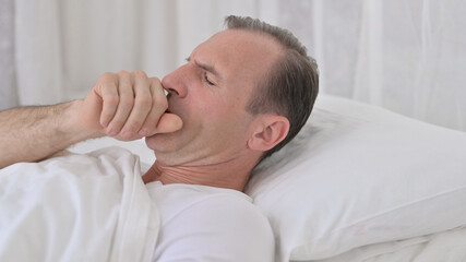 Fototapeta na wymiar Coughing Sick Middle Aged Man Sleeping in Bed