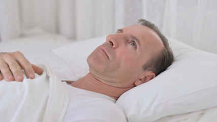 Pensive Middle Aged Man Awake in Bed Thinking