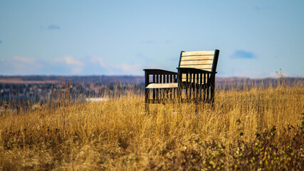 lone empty chair in autumn grass on hilltop