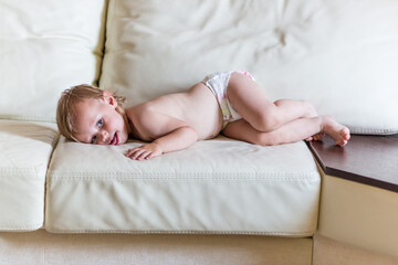 Obraz na płótnie Canvas Cute baby girl in diapers lying on bed