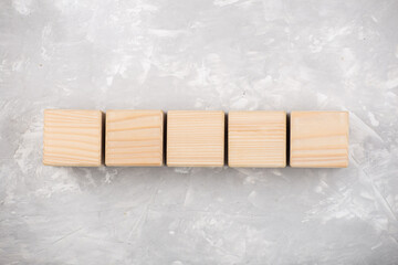 Natural empty wooden cubes on grey background