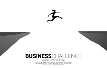 silhouette of businesswoman jumping over the gap of valley. concept of business challenge risk.