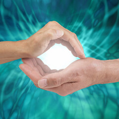 Our combined energy creates an unbeatable healing power - female hand cupped above male cupped hand...