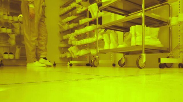 Low angle view of medical workers in the dressing room of biolab, taking of shoes after work