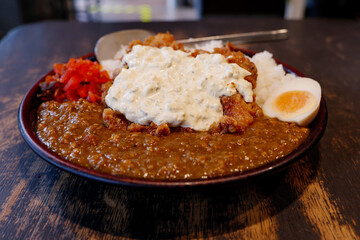 Close up view at Japanese Fried Chicken Nanban style curry with rice, boiled egg and red pickled vegetable. 