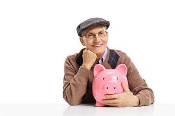 Happy elderly man sitting and hugging a pink piggy bank