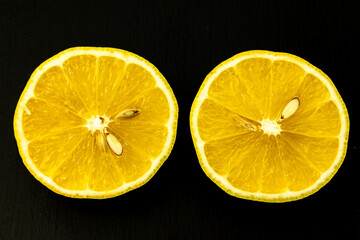 Yellow lemon in a cut. Close-up on a black background.