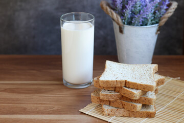 Whole Wheat Sliced Bread with milk on wooden table.