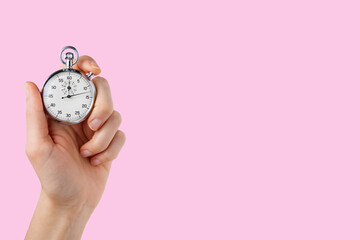 stopwatch hold in hand, button pressed, pink background