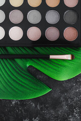 natural ingredients in cosmetics, neutral tones eyeshadow palette on tropical leaf
