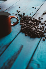 roasted coffee beans filtered coffee orange cup on turquoise wooden old table