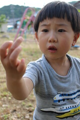 指についた虫を嫌そうに見つめる日本人の子供