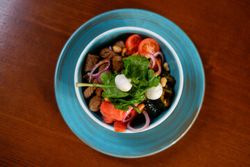 Fresh salad with meat, cheese, tomatoes and herbs. The concept of fast preparing healthy, tasty and hearty meals.
