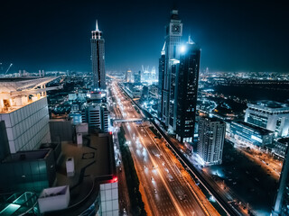 Fototapeta na wymiar Dubai skyline at night, urban skyscrapers and car traffic, view from above, United Arab Emirates.