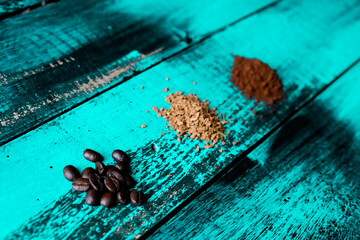 roasted ground coffee beans in different sizes on top of turquoise old wooden table