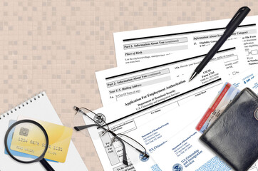 USCIS form I-765 Application for employment authorization lies on flat lay office table and ready...