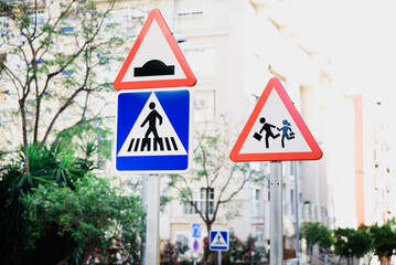 Traffic signs warning of children and pedestrian walks in an urban area.
