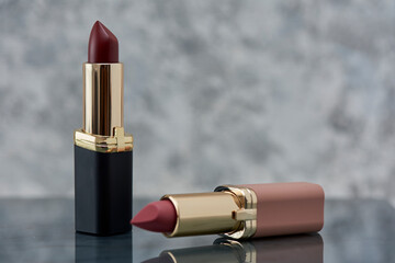 Labiales rojo y rosa acomodados sobre una base de marmol blanco