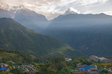 The peaks of the mountains of Nepal among the trees are the landscape of the Himalayas
