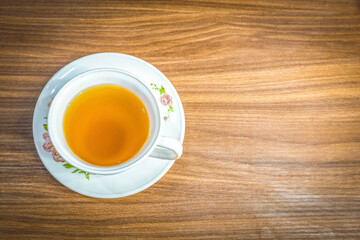 Camomile tea in the white cup placed on the wooden table