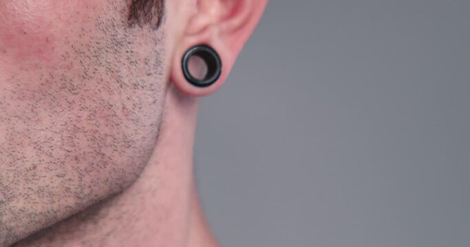 Young man with black tunnels in the ears