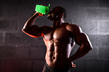 African American male athlete drinks sports nutrition from a shaker