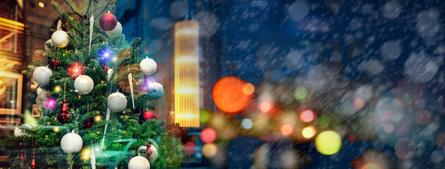 ショーウィンドウに飾られたクリスマスツリーとガラスに映る雪降る街の景色