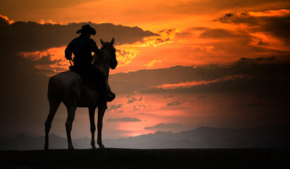 Fototapeta na wymiar Silhouette Cowboy on horseback. Ranch