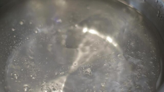 Boiling water mixed with oil in a cooking pot. Preparing a meal.