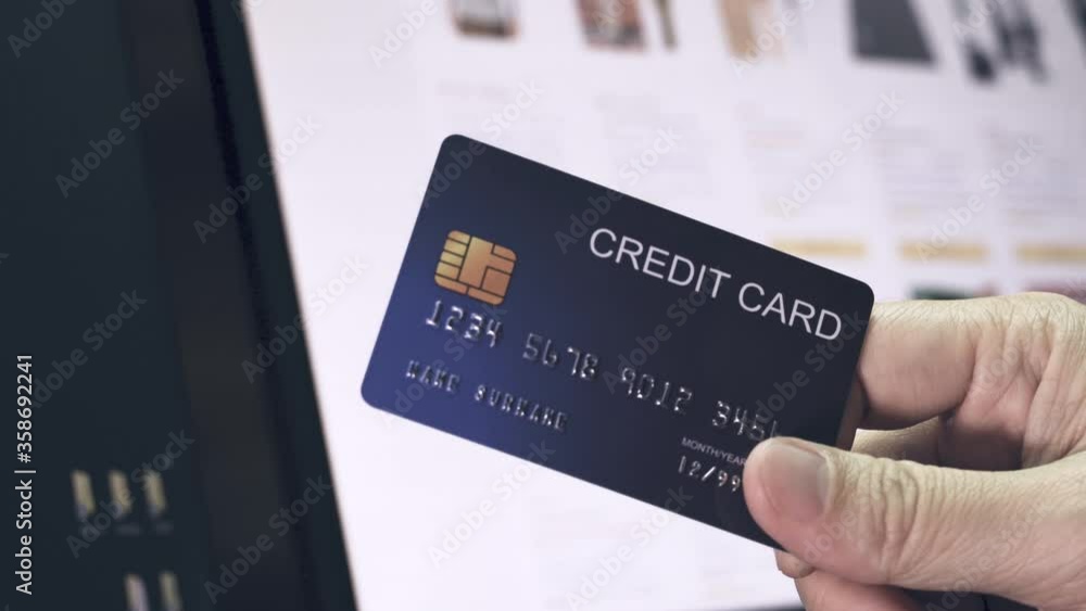 Poster 4k video pan shot hand hold credit card in front of ecommerce website in monitor. video concept for 