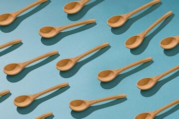 Background of a large number of wooden spoons on a blue background.