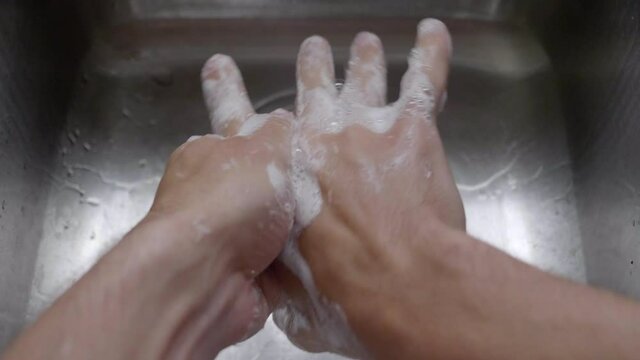 Closeup Of A Person's Hand Washing With Soap Under Clean Tap Water From A Faucet - High-Angle Shot