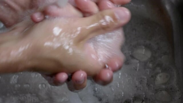 Person's Hand Washing With Soap Under Clean Tap Water From A Faucet - To Prevent Corona Virus - High-Angle Shot