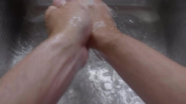 Closeup Of A Person's Hand Washing With Soap Under Clean Tap Water From A Faucet - High-Angle Shot