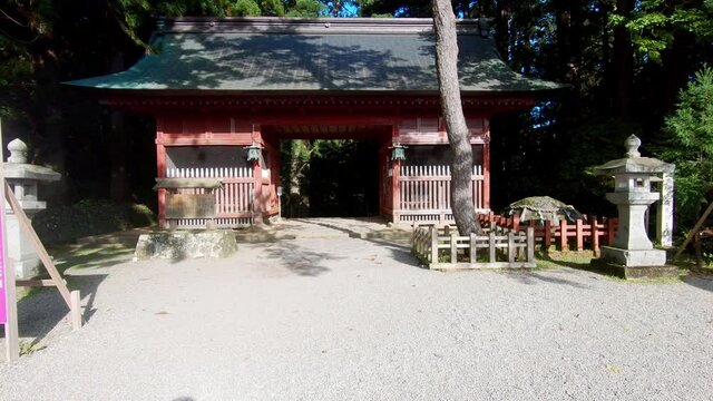 Walking towards the red entrance gate of haguro shrine in Japan. Dolly in