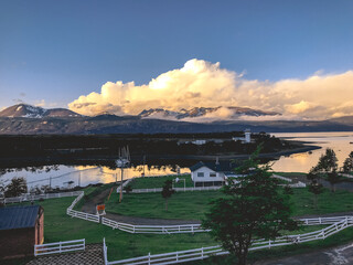 Panorama of Puerto Williams, the sea and nature in a beautiful day with blue sky and golden clouds,...
