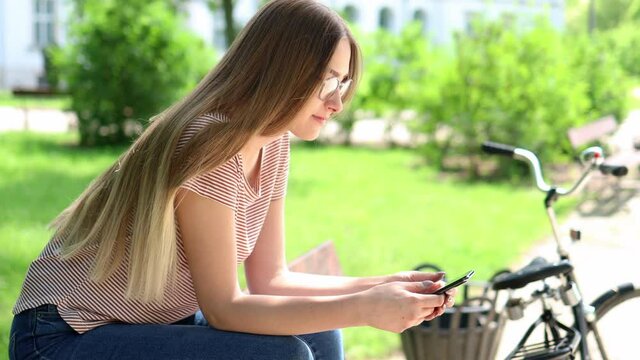 Attractive young woman using smartphone outdoors
