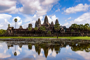 Fototapeta na wymiar It's Angkor Wat (Temple City) and its reflection in the lake, a Buddhist, temple complex in Cambodia and the largest religious monument in the world. View from the garden