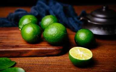 fresh limes with slice and leaves on dark background
