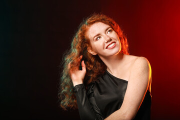 Portrait of beautiful redhead woman on dark background