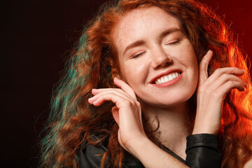 Portrait of beautiful redhead woman on dark background