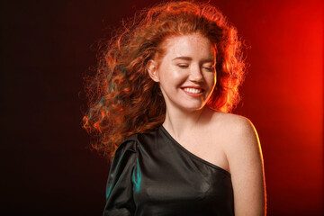 Portrait of beautiful redhead woman on dark background