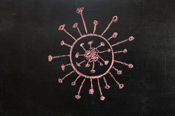 Drawing of a coronavirus bacterium on a chalkboard in red chalk.